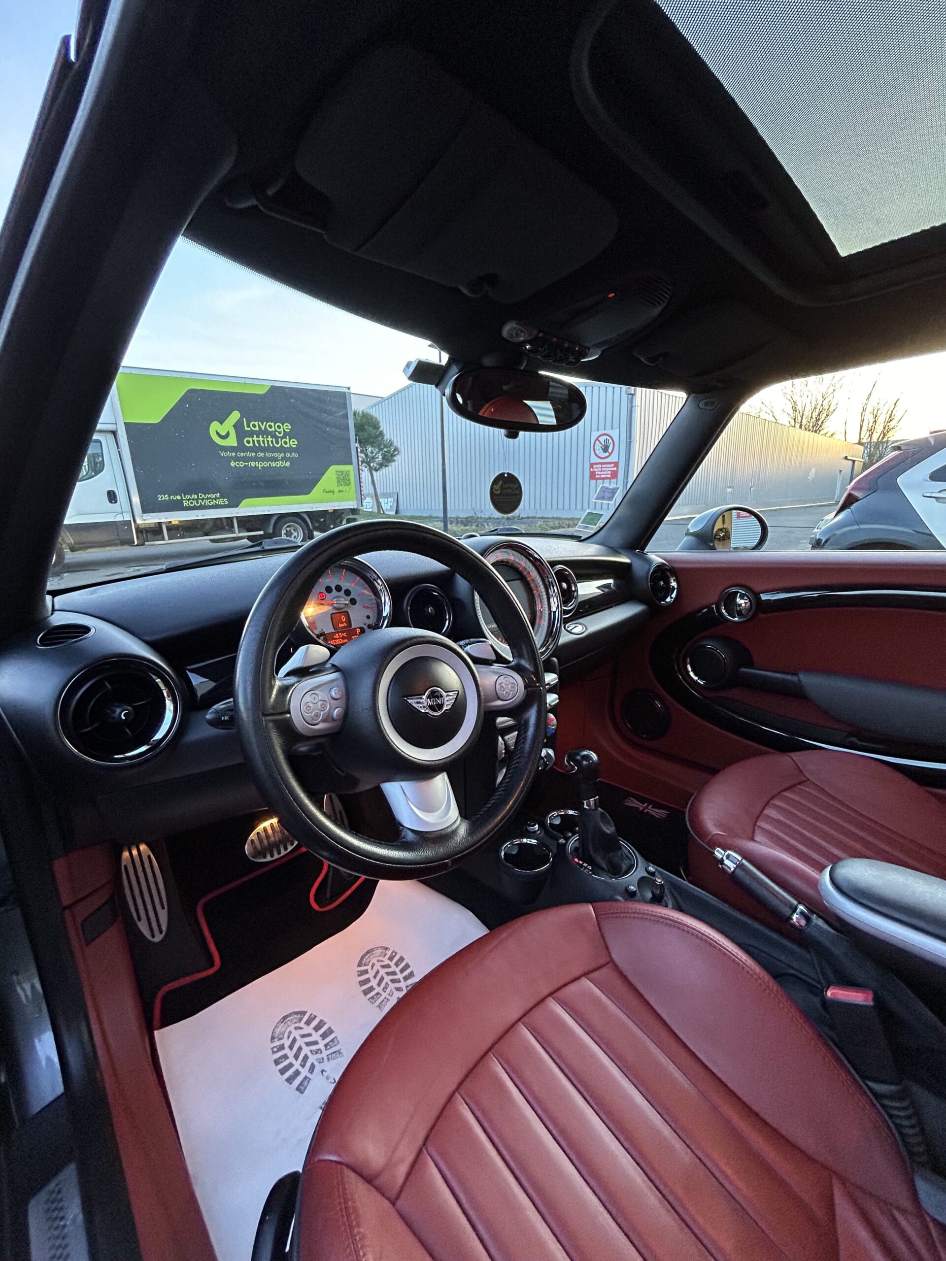 intérieur d'une mini cooper S en cuir rouge après une rénovation du volant et du pommeau en cuir